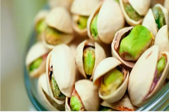 Open pistachio shells showing the bright green kernels inside